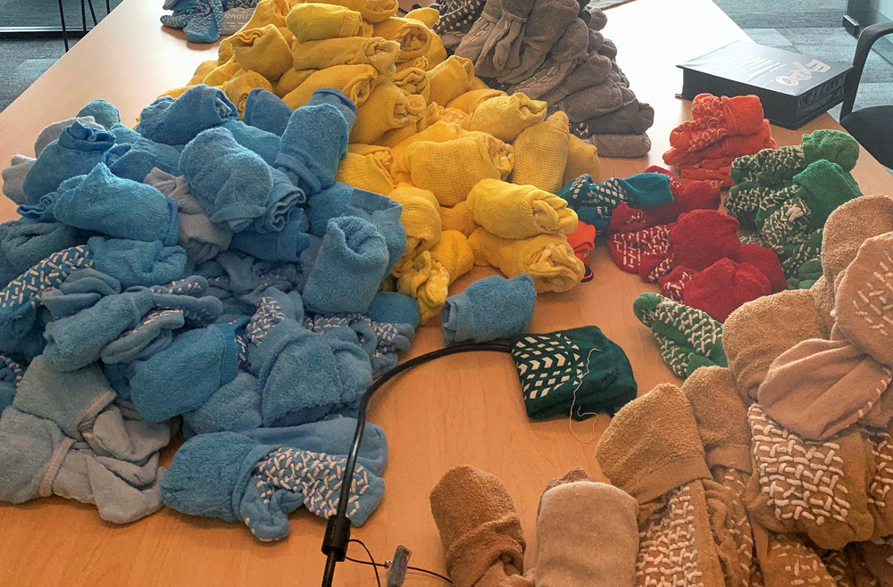 Dozens of skid-free hospital socks line a conference room table